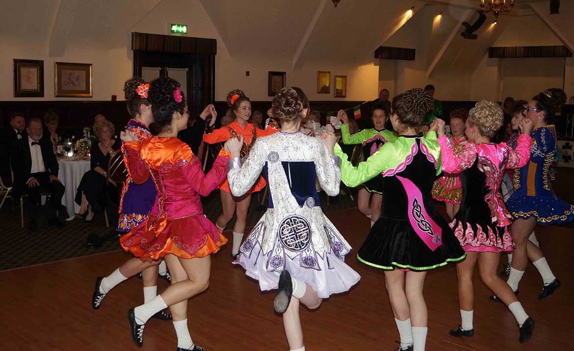 Irish society watching children dance at an event in Norwich